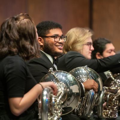 music students in horn section of orchestra during per为mance